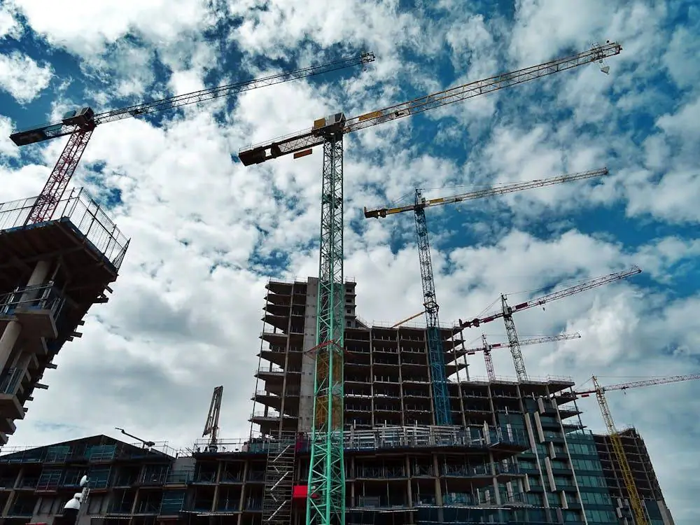 building under construction with cranes and blue skies